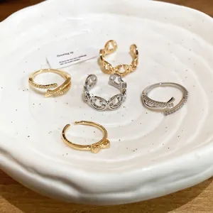 Elegant Korean style bow and zircon open rings set on a white ceramic display plate