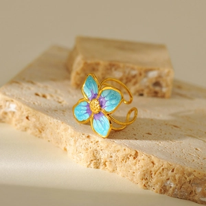 Detail of gold plated stainless steel ring with blue and purple enamel flower design