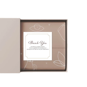 Minimalist square thank you card on abstract patterned liner inside a beige gift box