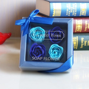 Close-up of four realistic blue soap roses in a square gift box with ribbon