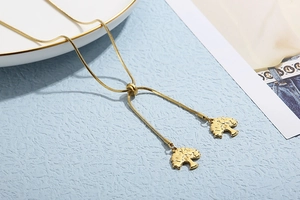 Vue détaillée du collier chaîne serpent dorée avec pendentifs arbre de vie réglables