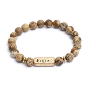 Detail of Belief engraving on golden metal bead with natural brown jasper stone beads