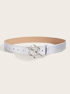 Detail of silver rhinestone star buckle and metallic PU leather belt on beige background
