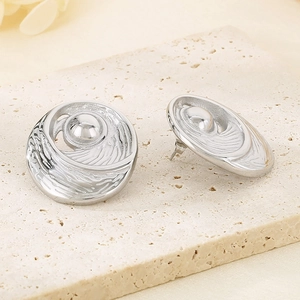Macro shot of silver stud earrings with 3D wave texture and smooth metal bead details