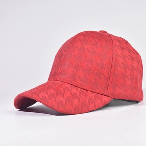 Close-up of red houndstooth wool baseball cap with thick texture and curved brim
