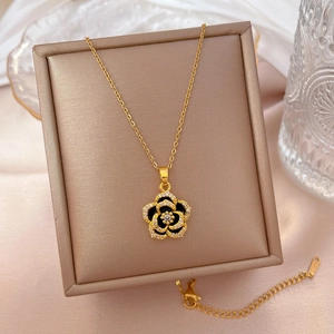 Detail of camellia pendant with crystals on gold titanium steel necklace in a box