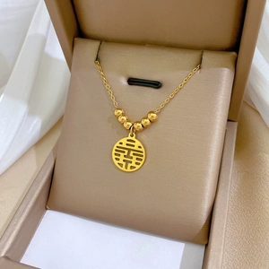 Close-up of golden Double Happiness pendant necklace in a luxury jewelry gift box