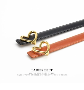 Detail of minimalist leather waist belts with elegant gold heart-shaped buckles in black and brown