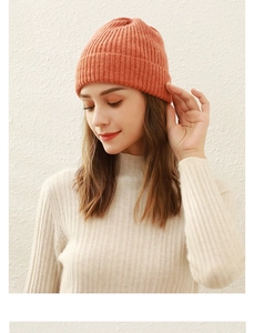 Detailed close-up of orange knit beanie texture and vertical ribbed stitch pattern