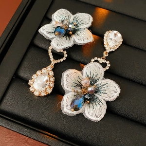 Vue détaillée de boucles d'oreilles vintage avec fleurs brodées et pendentifs cristal