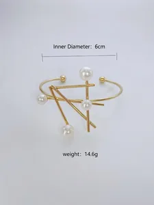 Close-up detail of irregular geometric gold bracelet featuring elegant white pearl accents