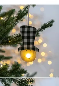 Glow-in-the-dark wooden snowman ornament with buffalo plaid hat on a Christmas tree
