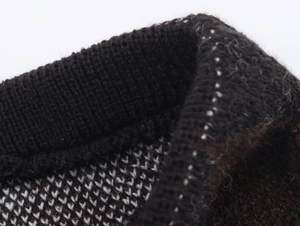 Close-up of the black knit fabric texture and high-neck collar detail on the sweater