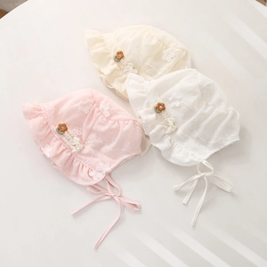 Detailed view of three lace baby bonnets featuring delicate floral embroidery and bows