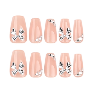 Short trapezoid press-on nails in nude pink with silver bows and rhinestone accents