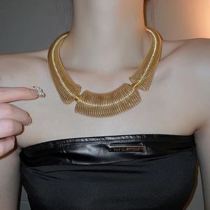 Close-up of chunky gold spiral spring necklace on neck for high-fashion jewelry detail