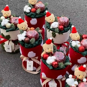 Christmas gift bucket with plush teddy bear, red berries, and holiday ornaments