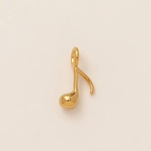 Détail macro d'un pendentif note de musique en acier inoxydable plaqué or 18 carats poli