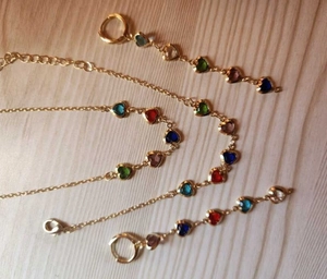 Vue rapprochée du set collier et boucles d'oreilles cœur coloré sur bois clair