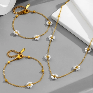 Elegant gold stainless steel jewelry set featuring daisy pearl necklace and bracelets