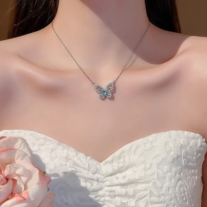 Elegantly worn butterfly pendant necklace with sea blue stone and white zircons