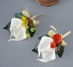 Detail of calla lily boutonnieres with orange silk flowers and gold ribbons for weddings