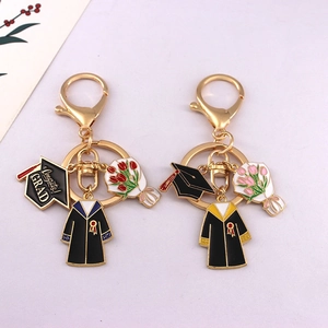 Golden graduation keychains featuring doctor hats, gowns and colorful tulip charms