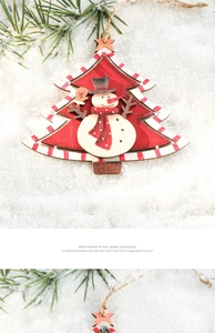 Macro shot of wooden Christmas tree ornament with snowman motif on snow and pine branches