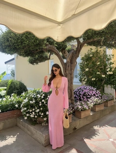 Detail of pink knitted maxi dress featuring a deep V-neckline and stylish waist cut-outs