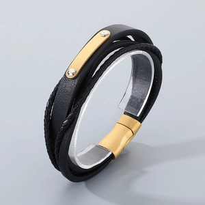 Detail of multi-layer black braided leather bracelet with golden magnetic metal clasp