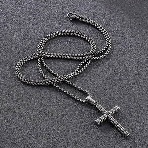 Gros plan détaillé d'un pendentif croix en acier argenté avec motif de briques texturées
