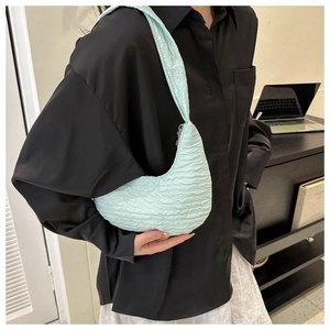 Detail showing mint green pleated texture and zipper of the chic crossbody bag