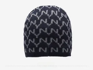 Detail view of the back of a navy blue knit beanie with gray NY letter jacquard patterns