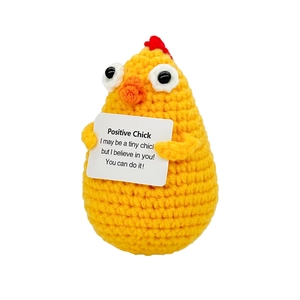 Detail of handmade yellow crochet chick holding a positive motivational card