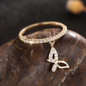 Detailed close-up of a golden butterfly pendant ring with micro-pave cubic zirconia crystals