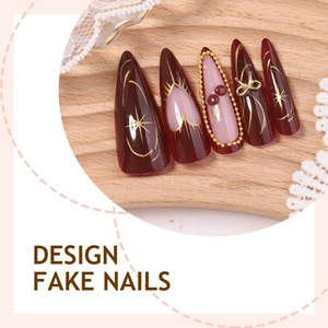 Long almond fake nails with red wine color, gold bow accents and pearl chain details