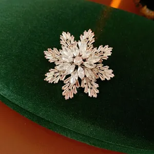 Elegant silver snowflake brooch with brilliant zircons on a dark green velvet background