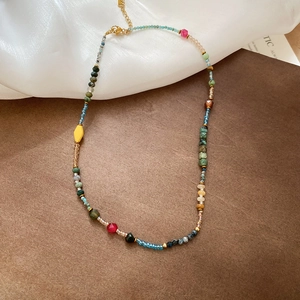 Detailed shot of multi-colored natural stone beaded necklace with gold plated clasp
