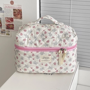 Close-up of quilted cosmetic bag with gray rabbit and pink heart prints and zipper detail