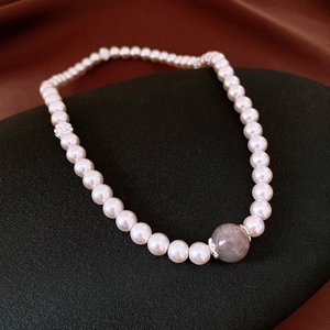 Gros plan d'un bracelet de perles avec zircons et pierre fine gris violet