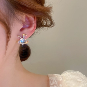 Close-up of star rabbit stud earring with resin stone on model ear
