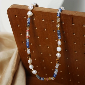 Bohemian handmade beaded necklace with freshwater pearls and colorful glass beads on wood