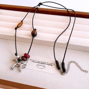 Détail du collier en perles de bois œil de tigre avec pendentif cheval en argent ciselé