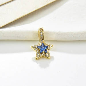Detailed view of a gold star pendant with blue zircon stone and pavé crystal edges