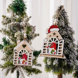 Nahaufnahme eines hölzernen Weihnachtshauses mit einem festlichen Zwerg mit roter Mütze