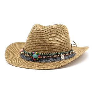 Détail d'un chapeau de cowboy en paille avec perles ethniques et boucle turquoise