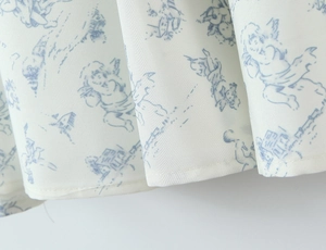 Détail du tissu floral bleu français avec motif cupidon et ourlet finement piqué