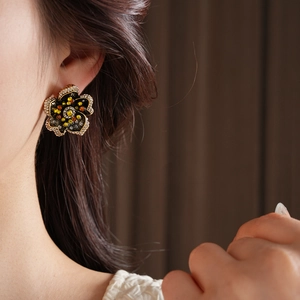 Detail of vintage flower stud earrings with yellow and orange rhinestones on model