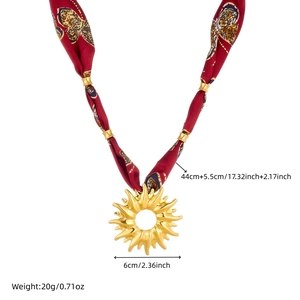 Detailed view of bohemian silk ribbon necklace with a large golden sun pendant and measurements