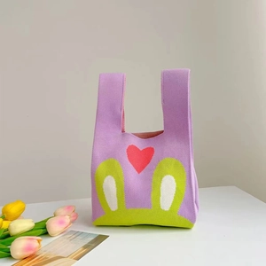 Minimalist purple knit tote bag with cartoon patterns and heart decor on a desk